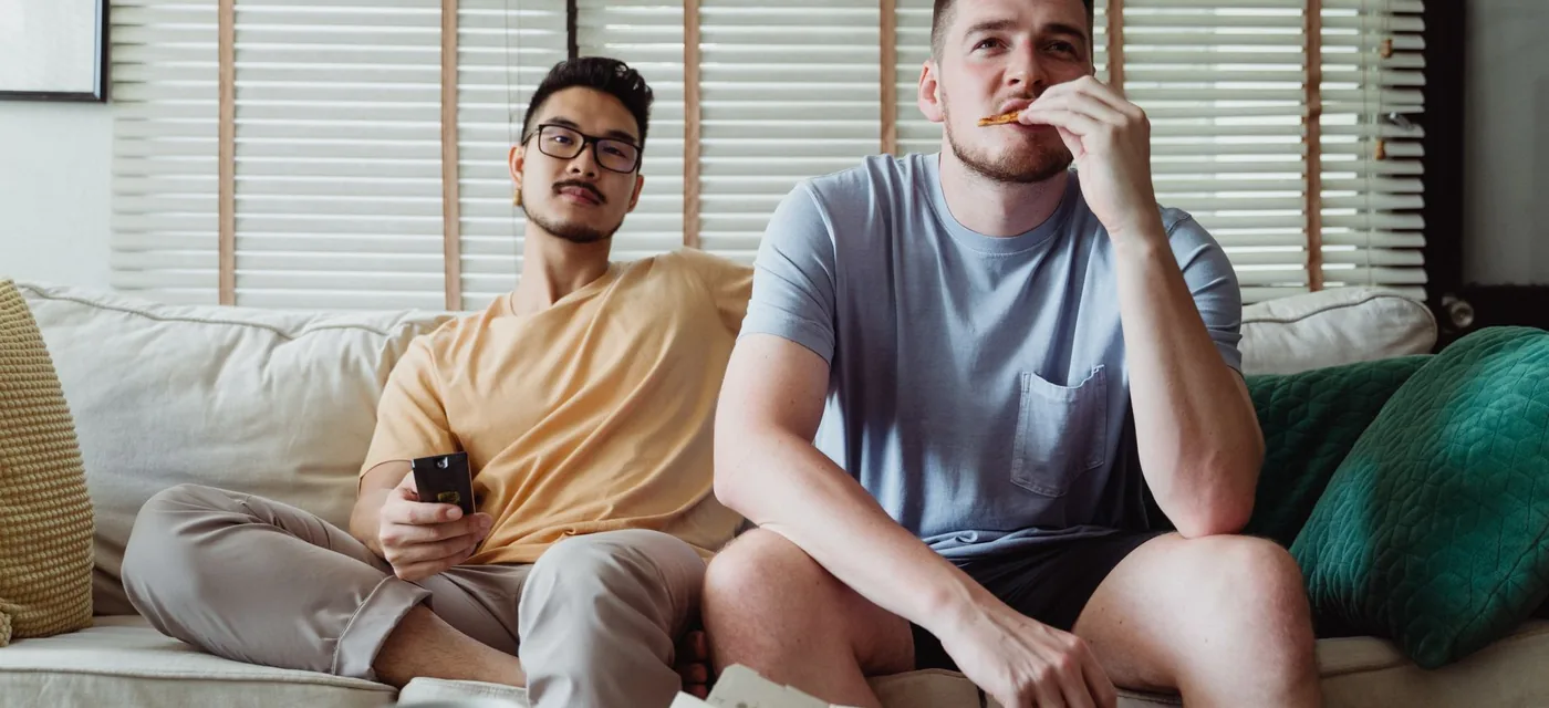 Dois amigos no sofá assistindo TV durante o teste IPTV grátis